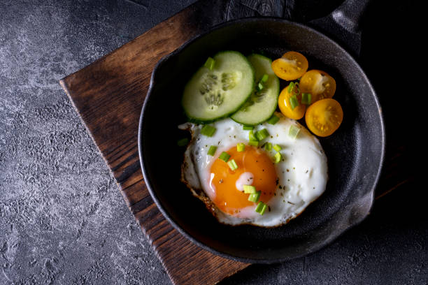 istock breakfast with fried eggs in a pan with bacon and vegetables on dark background 1360067741