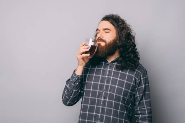 un homme hipster avec la barbe buvant du café aromatisé chaud. homme les yeux fermés en train de déguster un café. - male mug shot cut out one person photos et images de collection