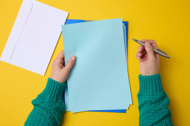 istock blank white sheets and two female hands, top view. Text writing, list 1360069714