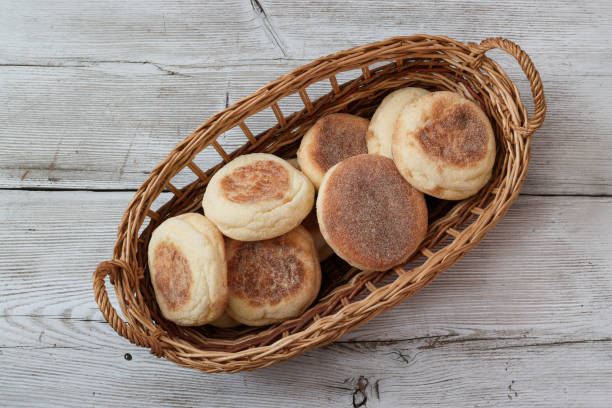 English muffin in the basket isolated on a wooden background. English muffin in the basket isolated on a wooden background. english muffin stock pictures, royalty-free photos & images