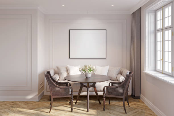Light classic interior with a blank illuminated horizontal poster over a light beige sofa, tulips in a vase on a wooden table, carved armchairs, blackout curtains near the window.