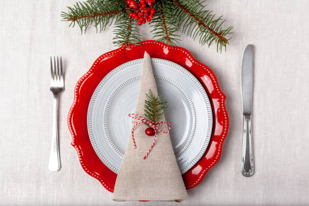 istock Simple table setting of a red and grey plates on a white tablecloth top view 1360072434