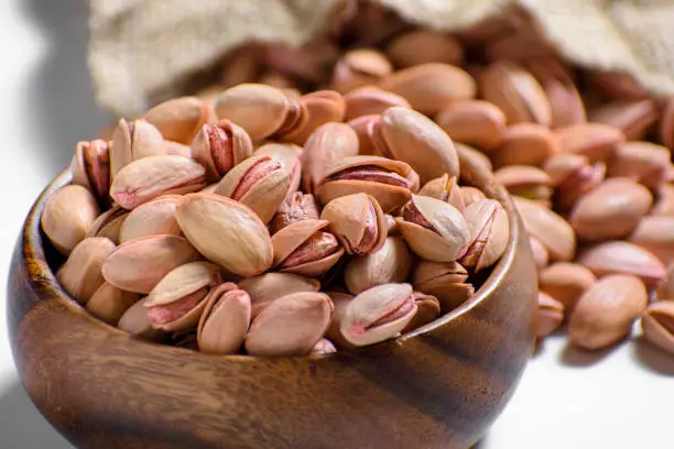 Close-up roasted pistachios in a bamboo bowl. Nuts from Gaziantep-Turkey region