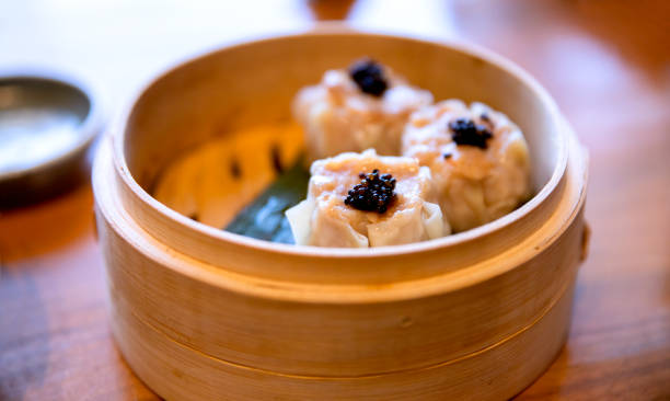 favourite uniquely Hong Kong dining experience Bamboo Steamer with Cooking with Siu Mai make of duck meat, quail egg and black caviar on top. Close up on excitement small Chinese bite food cantonese cuisine stock pictures, royalty-free photos & images