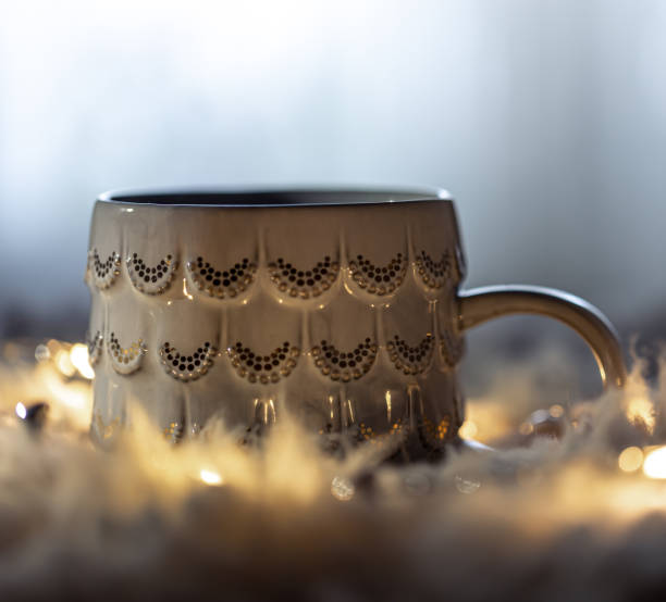 istock Beautiful cup on a blurred background in the dark with garlands. 1360082196