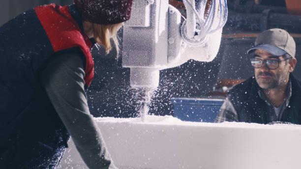 istock Man and woman cutting polymer in workshop 1360082213