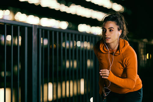 A fit night runner running fast on the railroad station at night. Night fitness, night running