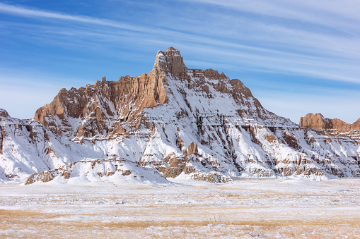 Scenic winter landscape with blue sky and fresh snow on the rock formations in Badlands National Park, South Dakota, USA.