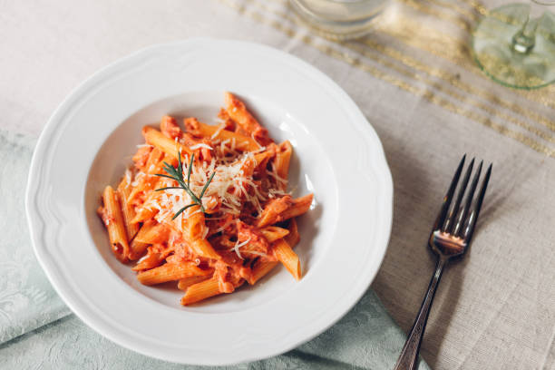 Penne alla Vodka pasta at dinner table vodka sauce with penne pasta and rosemary vodka sauce stock pictures, royalty-free photos & images