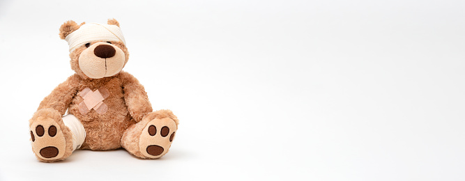 Teddy bear with bandage, child medical care concept. Bear on white background