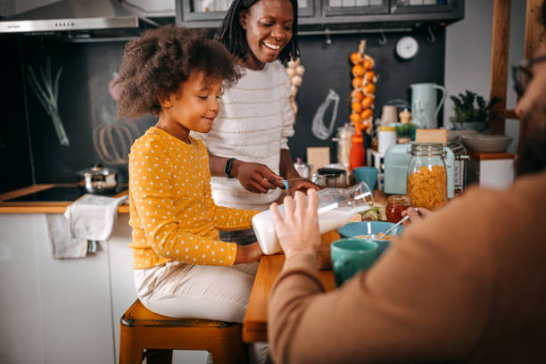 istock Father serving milk and corn flakes to daughter 1360089424