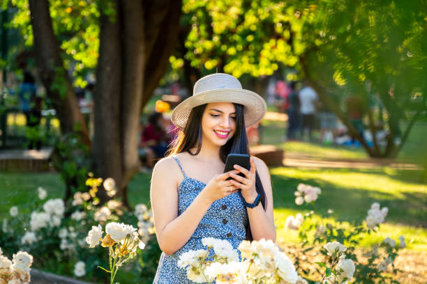 mujer joven usando un teléfono inteligente en el parque - chilean culture chile forest the americas fotografías e imágenes de stock