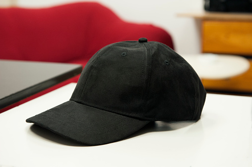 Black hat with visor on a white table