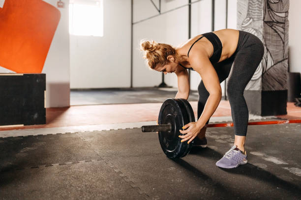 istock Female athlete putting weight on barbell 1360101066
