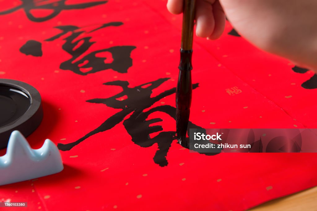 close up of writing spring festival couplets to celebrate Chinese new year holidays . close up of writing spring festival couplets to celebrate Chinese new year holidays .(the word  meaning lucky) Chinese Script Stock Photo