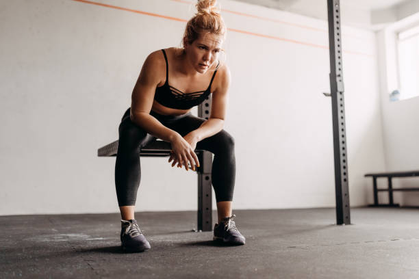 istock Exhausted woman in gym resting 1360104765