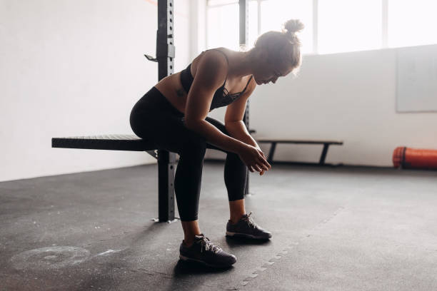 istock Exhausted woman in gym resting 1360104796