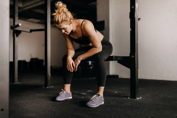 istock Exhausted woman in gym resting 1360104819