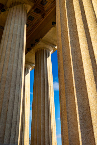 istock Three supporting columns in an ancient greek architectural style building during bright sunny day 1360108668