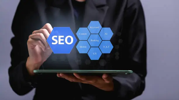 SEO Search Engine Optimization concept, Human hand pointing promoting ranking traffic on website, optimizing your website to rank in search engines or SEO on virtual screen over tablet.