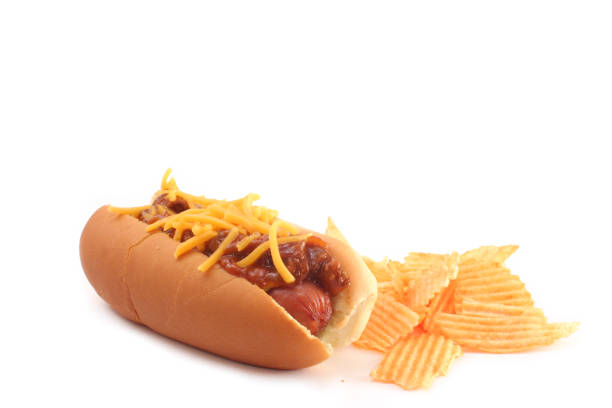 Hot dogs and French fries on white background. Sausages with tomato sauce and cherry tomatoes on a wooden Board.