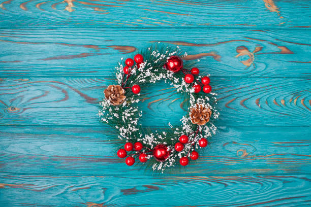 istock Christmas wreath on turquoise wooden background 1360114098