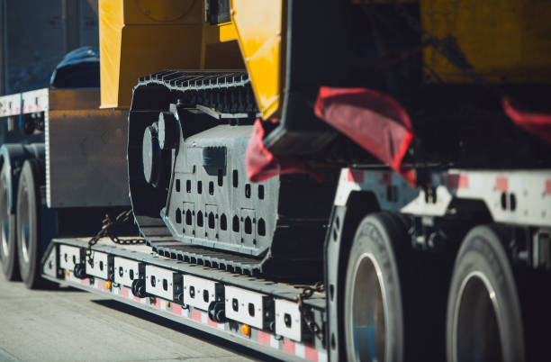 Heavy Duty Construction Machinery Transportation Long Haul Heavy Duty Construction Machinery Transportation on a Semi Truck Trailer. Excavator Delivery. construction equipment stock pictures, royalty-free photos & images