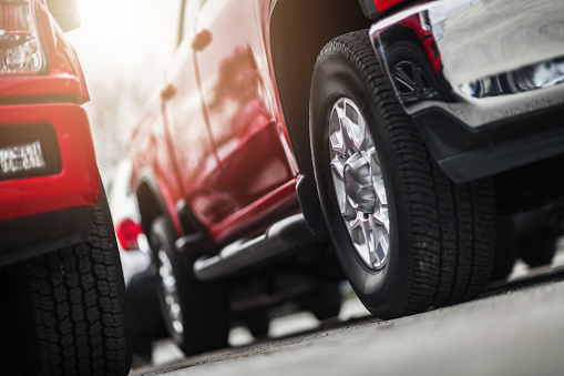 Modern Pickup Trucks For Sale Automotive Business Theme. Dealership Stock. Ground Level Wheel Close Up.