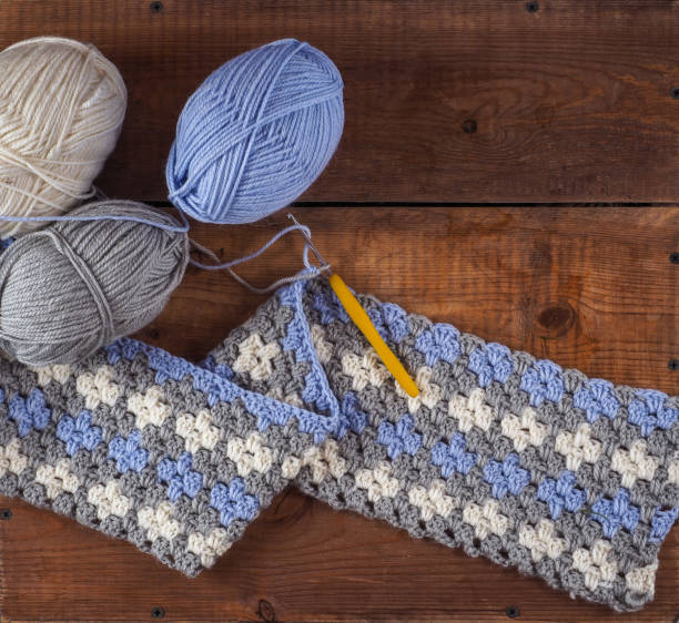 istock Multicolored crochet pattern, plaid fragment and yarn balls 1360115716