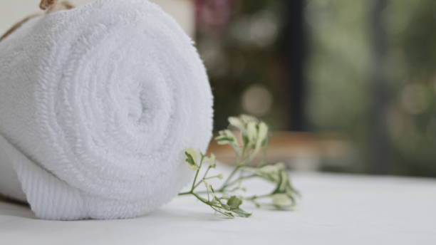istock Rolls of white towels placed on a wooden table including spa sets 1360116500