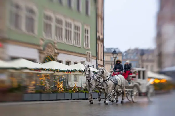 Photo of Horse carriages near St. Mary's Basilica and Christmas tree at Krakow market square, Poland.