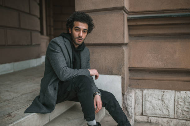 istock Young man is sitting on the stairs 1360122748