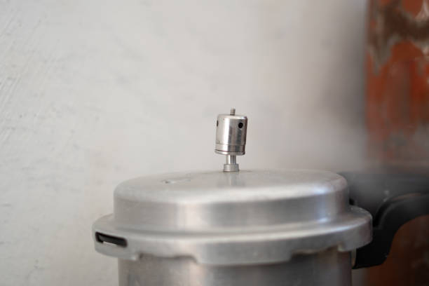 Steam releasing from a pressure cooker in a kitchen.
