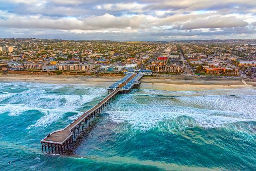 Aerial view of the Crystal Pier in the Pacific Beach community of San Diego, California shot from an altitude of about 800 feet over the ocean.