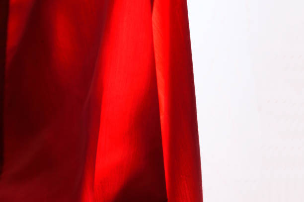 istock Closeup abstract of deep red cloth against white background. 1360129747