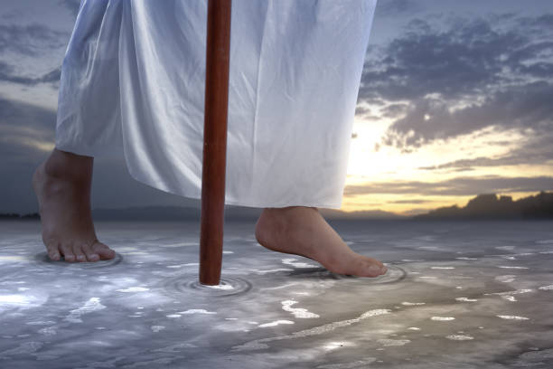 istock Jesus Christ walking with stick on the water 1360130547