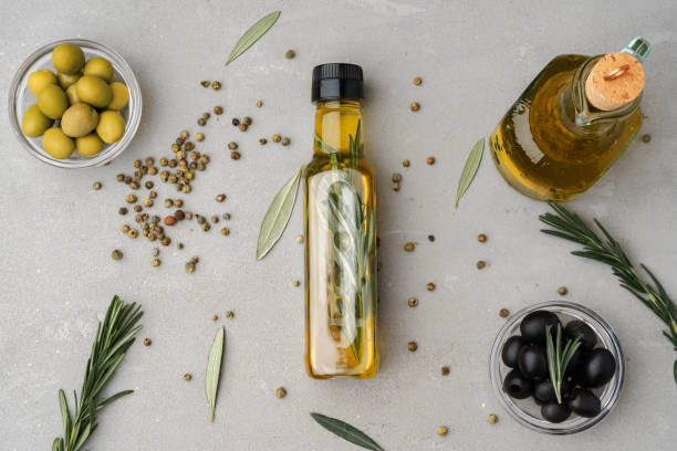 istock Glass bottle with olive oil on gray background 1360131584