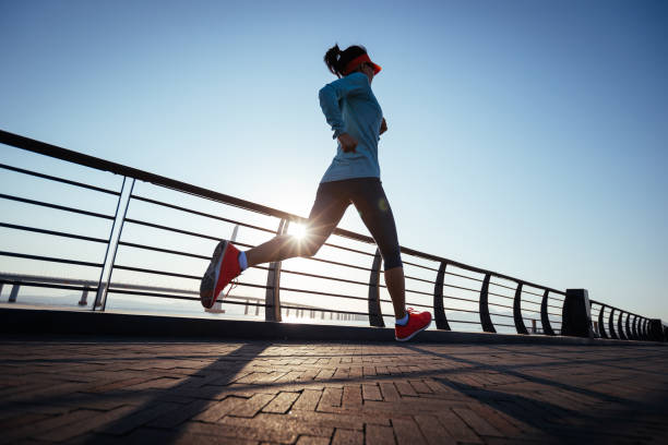 corridore donna fitness che corre sul ponte sul mare - jogging foto e immagini stock