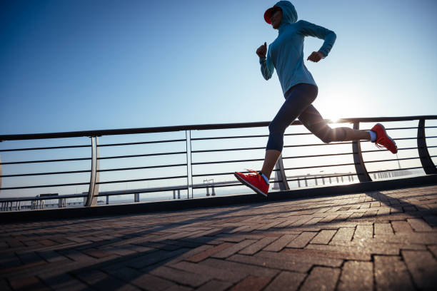 istock Fitness woman runner running on seaside bridge 1360133951