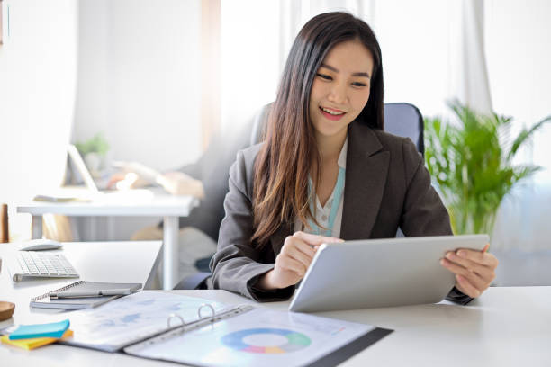 istock Businesswoman using digital tablet touchpad at her desk. 1360135733