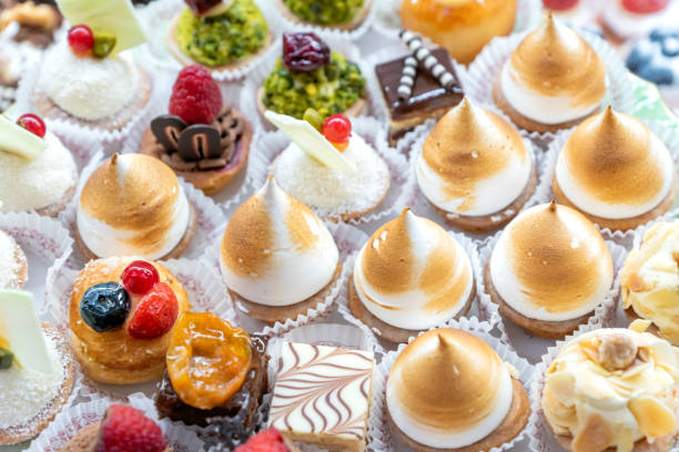 istock Assorted different mini cakes with cream, chocolate and berries- Sweets offered at the pastry shop 1360138374