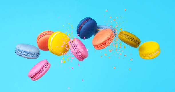 istock Macaroons. Flying colorful macarons on a blue background. 1360139810
