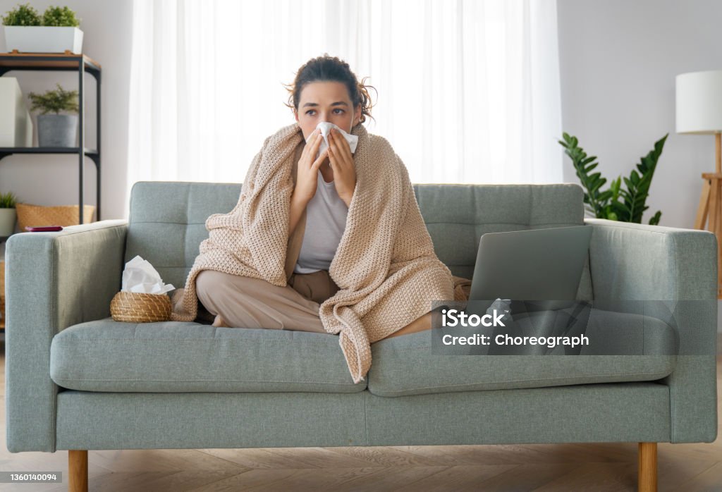 girl is holding paper tissue and blowing nose Ill upset girl is holding paper tissue and blowing nose. Virus symptom concept. Cold And Flu Stock Photo