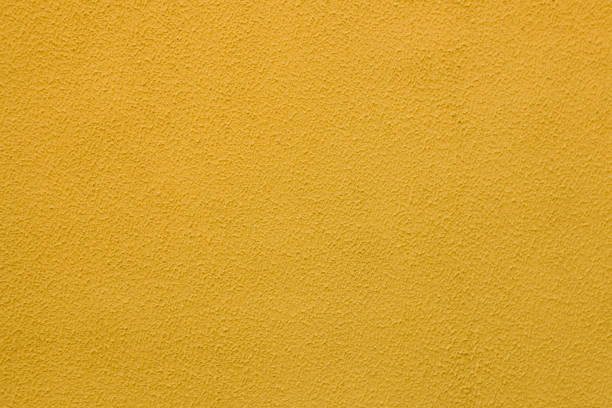 istock Abstract background of old worn yellow plaster on wall. 1360144766