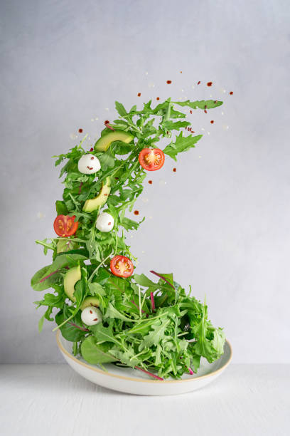 회색 콘크리트 벽에 테이블에 접시 위에 아루굴라 잎, 체리 토마토와 모짜렐라의 채식 샐러드를 부양 - salad mozzarella food balsamic vinegar 뉴스 사진 이미지