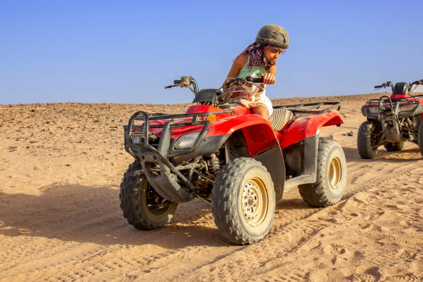 istock Girl driving ATV in the desert 1360145701