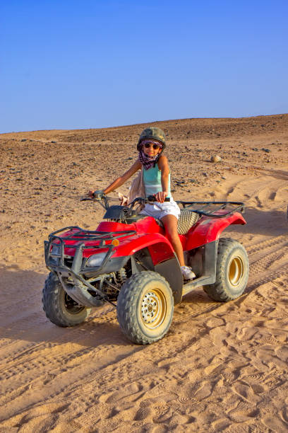 istock Girl driving ATV in the desert 1360145704