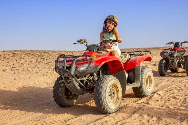 istock Girl driving ATV in the desert 1360145748
