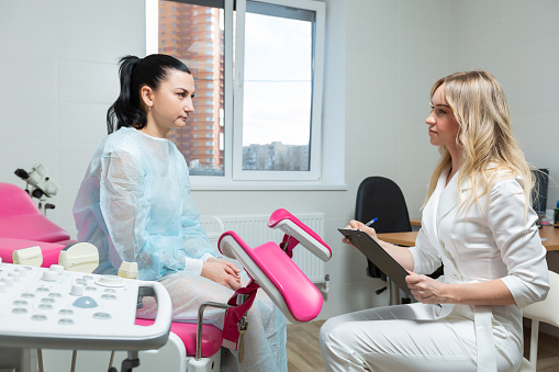 Photo of a gynecologist doctor and a patient on a gynecological chair. Preventive reception, preparation for medical examination, pregnancy management, health care gynecology contol.