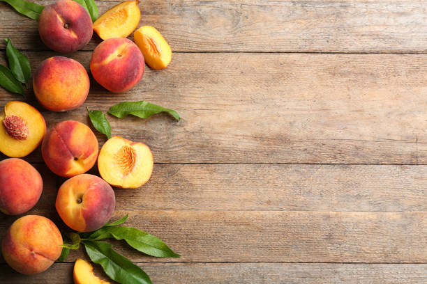 istock Fresh sweet peaches on wooden table, flat lay. Space for text 1360146034